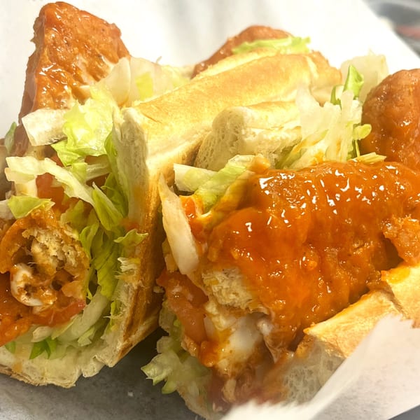 A Capo's Pizzeria buffalo chicken sub with lettuce, tomatoes, and orange sauce.